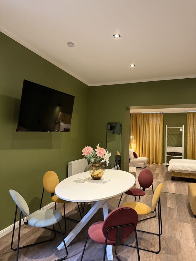 Wohnbereich mit rundem Esstisch und Ecksofa in den Prestige Suites